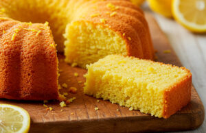 Porción de bizcocho de limón sin gluten y sin lactosa servida en un plato, con textura esponjosa y aroma cítrico, perfecta para el postre o la merienda